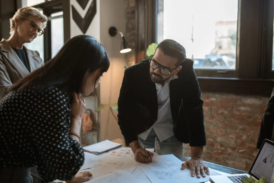 A diverse team collaborating on digital marketing strategies at a desk, using laptops and tablets.